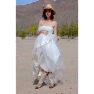 Cowgirl brides in the mid-day sun at an old church.